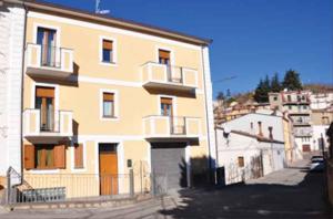 ein großes gelbes Gebäude mit einem Tor davor in der Unterkunft Cappuccini Guest House in San Giovanni in Fiore