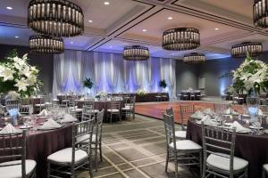 um salão de banquetes com mesas, cadeiras e lustres em Hyatt Regency Schaumburg Chicago em Schaumburg