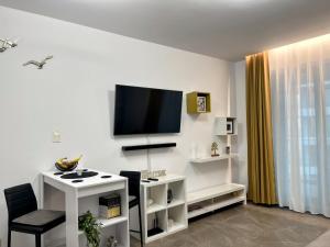 a living room with a tv on a white wall at Studio 147 Mamaia Nord in Mamaia