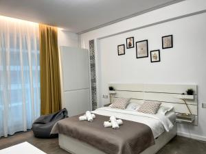 two stuffed animals sitting on a bed in a bedroom at Studio 147 Mamaia Nord in Mamaia