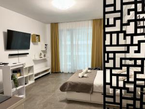 a bedroom with a bed and a flat screen tv at Studio 147 Mamaia Nord in Mamaia