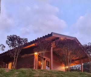 ein Haus auf einem Hügel mit Licht an in der Unterkunft Chalé Pavão Recanto Buscapé SFX in São Francisco Xavier