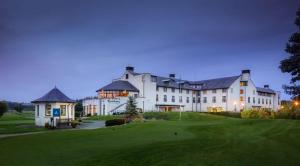 um grande edifício branco com um pátio verde em Doubletree by Hilton Belfast Templepatrick em Templepatrick