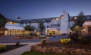 坦普尔帕特里克Doubletree by Hilton Belfast Templepatrick的一栋有很多窗户的白色大楼