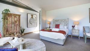 a bedroom with a bed and a table and a chair at Saltwater Creek - The Birds Nest in Bundannon