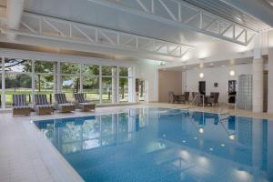 坦普尔帕特里克Doubletree by Hilton Belfast Templepatrick的建筑物内有蓝色水的大型游泳池