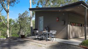 a house with a table and chairs on a patio at Saltwater Creek - The Birds Nest in Bundannon