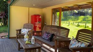 a porch with two benches and a red phone booth at Saltwater Creek - The Birds Nest in Bundannon +3 photos
