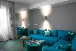 a living room with a blue couch and a table at Hotel Byron in Forte dei Marmi