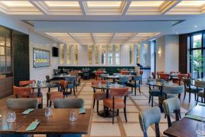 坦普尔帕特里克Doubletree by Hilton Belfast Templepatrick的一间有桌椅的餐厅