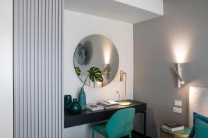 Zimmer mit einem Schreibtisch mit einem Spiegel und einem Stuhl in der Unterkunft Hotel Byron in Forte dei Marmi