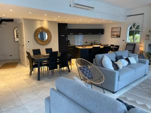 a living room with a couch and a dining room at Villa face mer in Royan