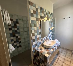 een badkamer met een wastafel en een spiegel bij Le Relais Notre Dame in Quinson