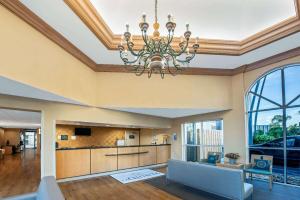 a living room with a chandelier in the ceiling at La Quinta by Wyndham West Palm Beach Airport in West Palm Beach