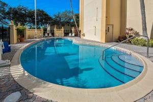 ein großer Pool in der Mitte eines Gebäudes in der Unterkunft La Quinta by Wyndham West Palm Beach Airport in West Palm Beach
