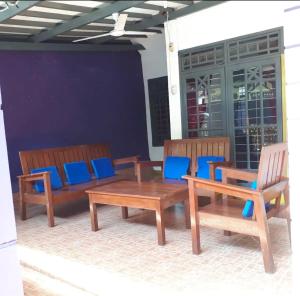 KJ Purple House Senggigi في سينغيغي: كرسيين خشبيين وطاولة ومقعدين