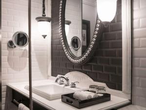 薩帕的住宿－Hotel de la Coupole - MGallery，一间带水槽和镜子的浴室