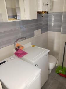 ein Badezimmer mit einem weißen Waschbecken und einem WC in der Unterkunft Cappuccini Guest House in San Giovanni in Fiore