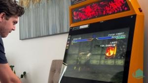 um homem a jogar um jogo de vídeo numa máquina de jogos de vídeo em Surfers Paradise em Catherine Hill Bay