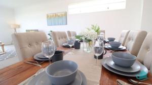 uma mesa de jantar com pratos e copos de vinho em Surfers Paradise em Catherine Hill Bay