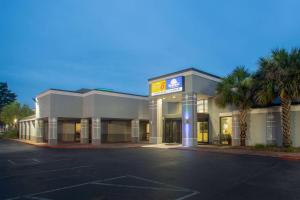 a store front of a hotel with palm trees at Days Inn by Wyndham Mobile I-65 in Mobile