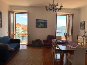 sala de estar con sofá azul y mesa de comedor en Casa Las Molas en La Maddalena