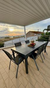 Une table et des chaises en bois sont disponibles sur la terrasse. dans l'établissement Casa "Vento" Ferragudo mit privatem Pool, à Ferragudo