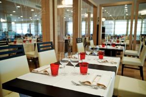 - une salle à manger avec des tables et des verres à vin rouge dans l'établissement Green Village Eco Resort, à Lignano Sabbiadoro