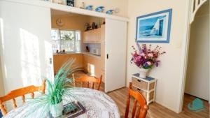 ein Esszimmer mit einem Tisch und einer Vase aus Blumen in der Unterkunft Bromyard Cottage in Swansea