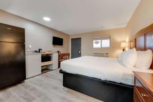 Habitación de hotel con cama grande y cocina en Suburban Studios near Mesa Verde, en Cortez