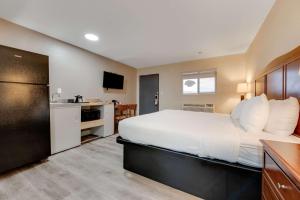 a hotel room with a large bed and a kitchen at Suburban Studios near Mesa Verde in Cortez