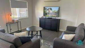 a living room with two couches and a table at Beachside Oasis in Caves Beach