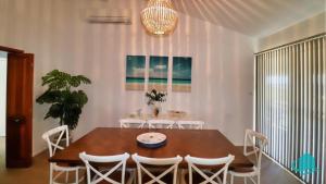a dining room with a wooden table and white chairs at Oceanview Beach House in Caves Beach