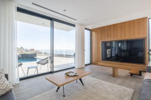 ein Wohnzimmer mit einem großen Flachbildfernseher in der Unterkunft Villa Elysian Oasis by Homie in Prazeres