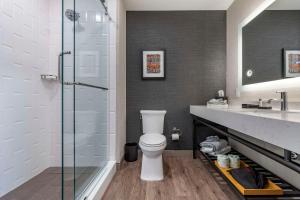 een badkamer met een toilet en een glazen douche bij Cambria Hotel Columbia Downtown the Vista in Columbia