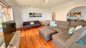 a living room with a couch and a table at Serendipity in Eraring