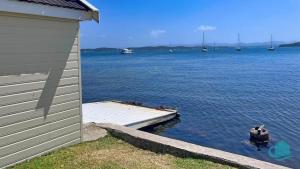 a house with a dock and a large body of water at Azure Vista in Belmont +11 photos