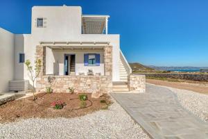 a white house with blue windows and a driveway at Paros Sea View Eco - Aetherian Ciel Villas, Alia in Mármara