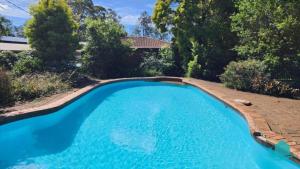 a swimming pool in a yard with a landscaping at Wemberley Lakehouse in Wangi Wangi