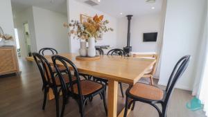 - une salle à manger avec une table et des chaises en bois dans l'établissement Kove, à Caves Beach