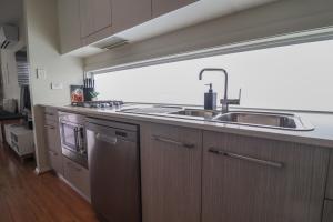 a kitchen with a sink and a large window at Haven at Caves in Caves Beach