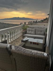 a balcony with two wicker chairs and a couch at VILLA ANDERR in Sarandë
