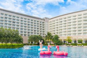 um resort com flamingos cor-de-rosa na água em frente a um edifício em Wyndham Grand Phu Quoc em Phu Quoc