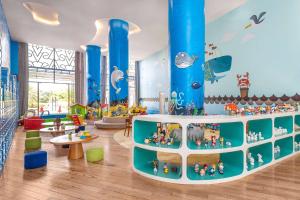 uma área recreativa para crianças com colunas azuis e brinquedos em Wyndham Grand Phu Quoc em Phu Quoc
