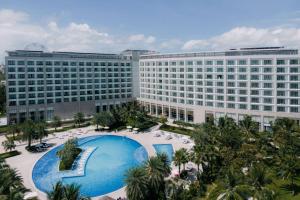 een groot gebouw met een groot zwembad ervoor bij Wyndham Grand Phu Quoc in Phu Quoc