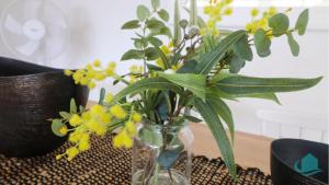 a vase filled with yellow flowers on a table at Charlottes Rhapsody in Bonnells Bay