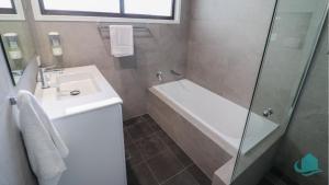 un bagno con vasca, lavandino e doccia di Charlottes Rhapsody a Bonnells Bay Altre 17 foto