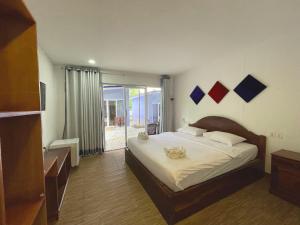 een slaapkamer met een groot bed en een glazen schuifdeur bij Scarlet Sails Resort in Koh Rong Island