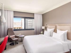 阿比让Mövenpick Hotel Abidjan的一间带床、椅子和窗户的酒店房间 更多37张照片