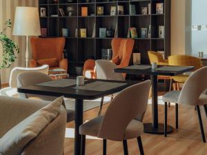 華沙的住宿－華沙機場智選假日酒店，书架的房间设有两张桌子和椅子